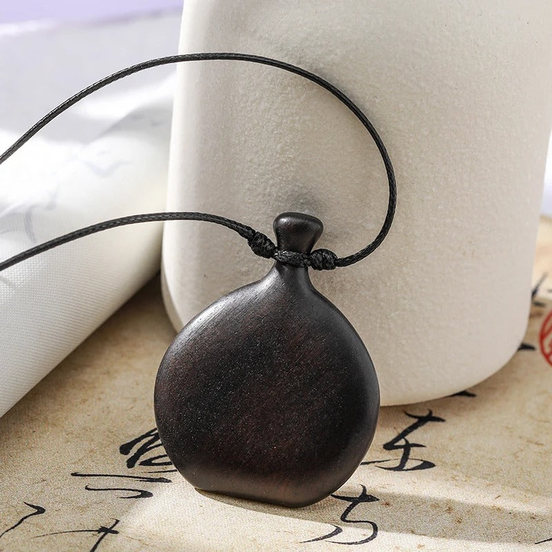 Collier long mixte en bois naturel de santal noir avec pendentif élégant de style bohème et chic.