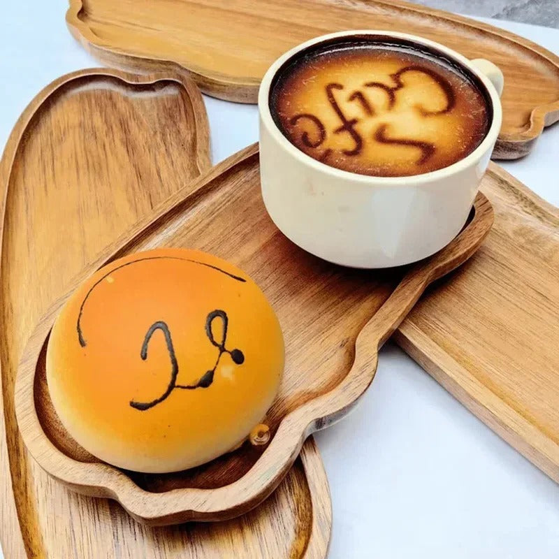 Petite assiette en bois d'acacia servant un café et une pâtisserie, idéale pour le petit-déjeuner ou une pause gourmande.