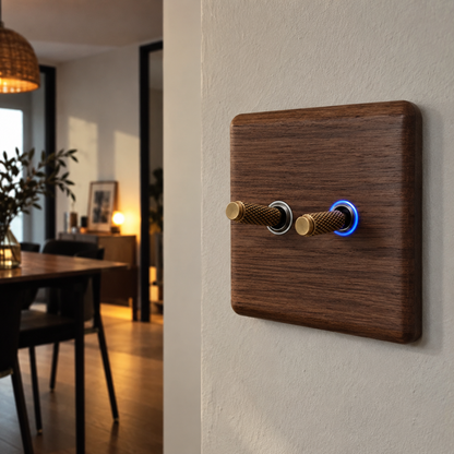 Interrupteur en bois de noyer avec LED bleue et levier en laiton installé au mur